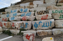 رشّ عبارات ورسومات من بينها "لفظ الجلالة" على الحجارة مقابل شاطئ الجبلية